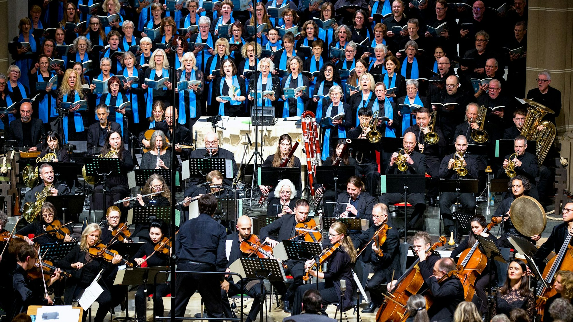 Ein Chor und Orchester sind im Altarraum einer Kirche aufgestellt.