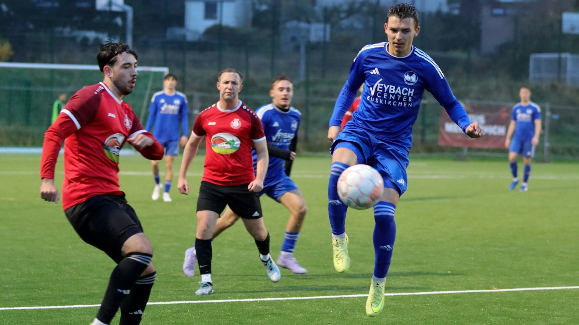 Sven Stanienda von Weilerswist springt in die Luft, der Ball ist vor ihm. Es ist nicht zu erkennen, ob er schießt oder den Ball annimmt. Ein Gegenspieler beobachtet ihn.