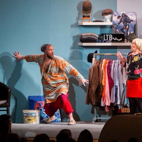 Fünf Schauspieler stehen auf einer Bühne und führen ein Stück auf.