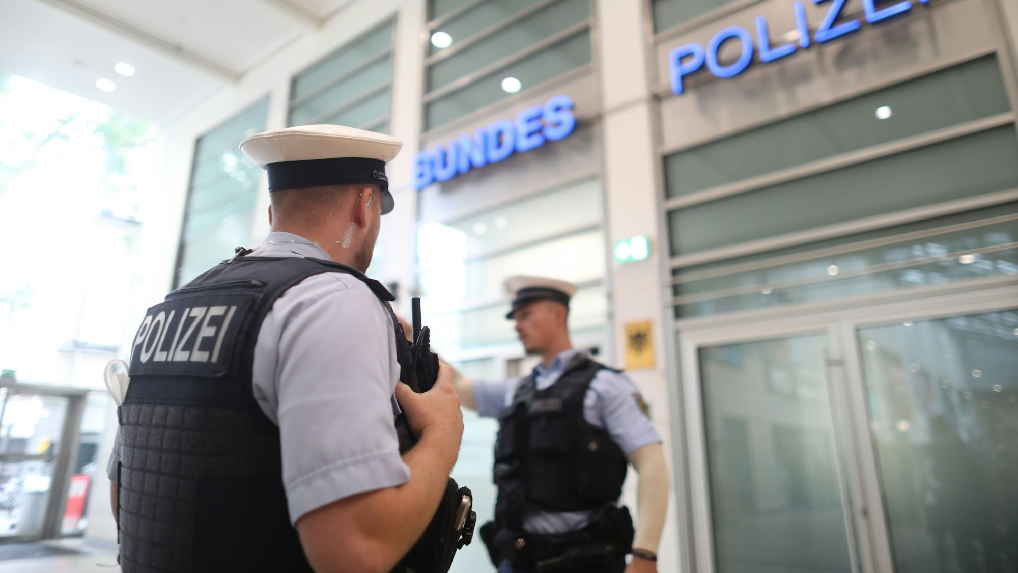 zwei Polizisten stehen vor der Wache der Bundespolizei im Kölner Hauptbahnhof