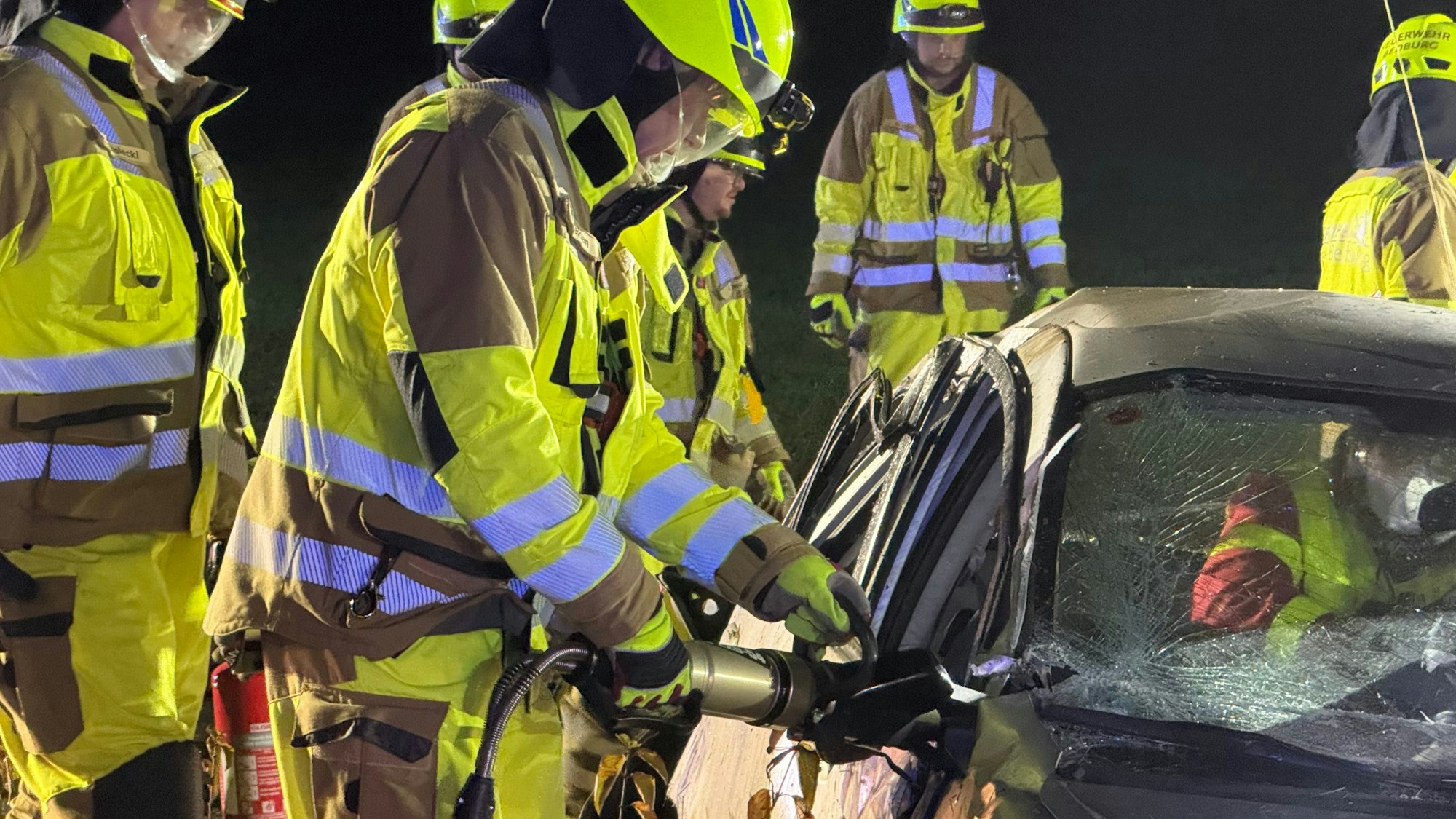 Das Bild zeigt einen verunglückten Pkw mit mehreren Einsatzkräften der Feuerwehr.