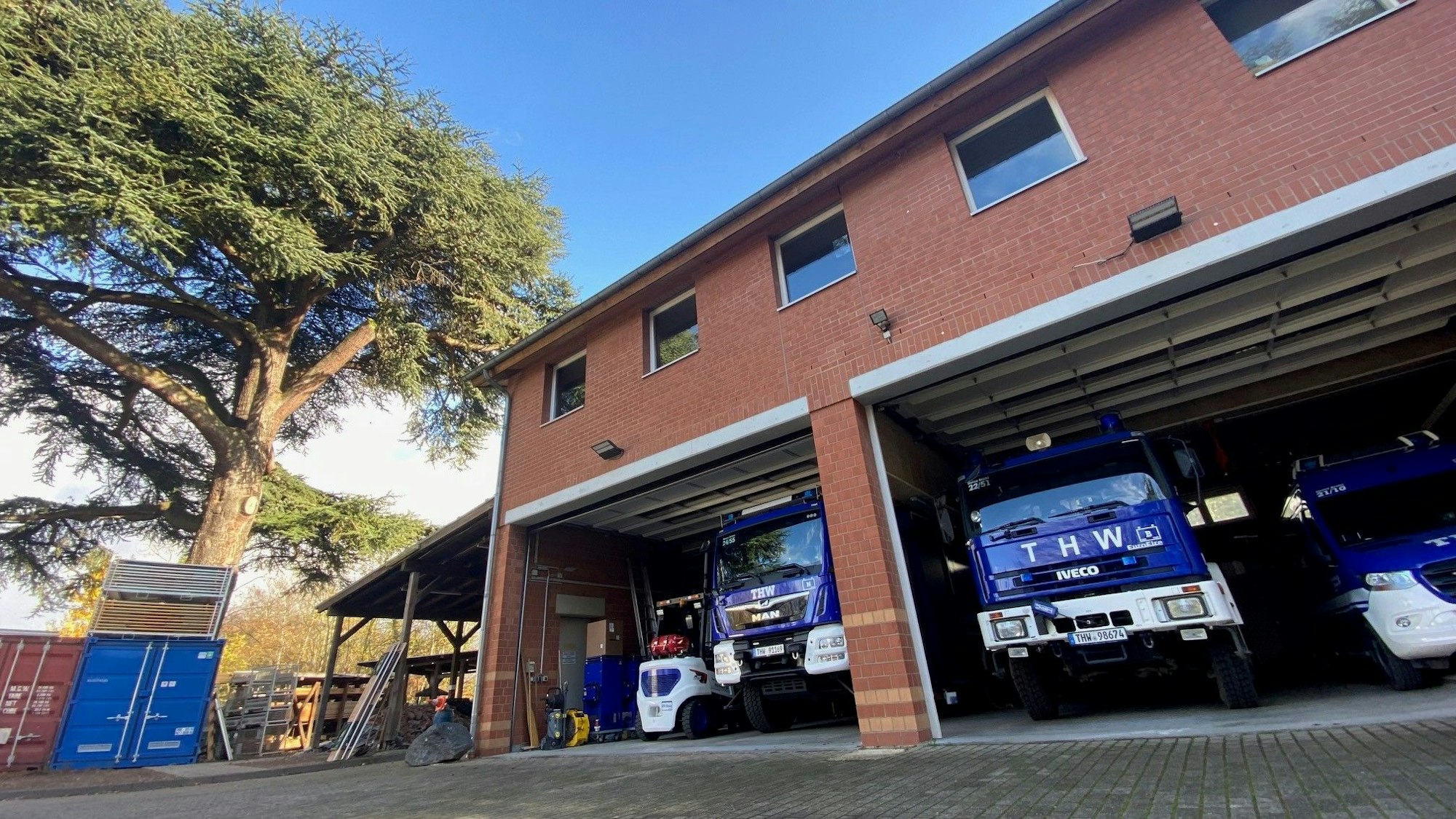 Zu sehen ist das Gebäude des THW in Brühl, in dem Einsatzfahrzeuge stehen.