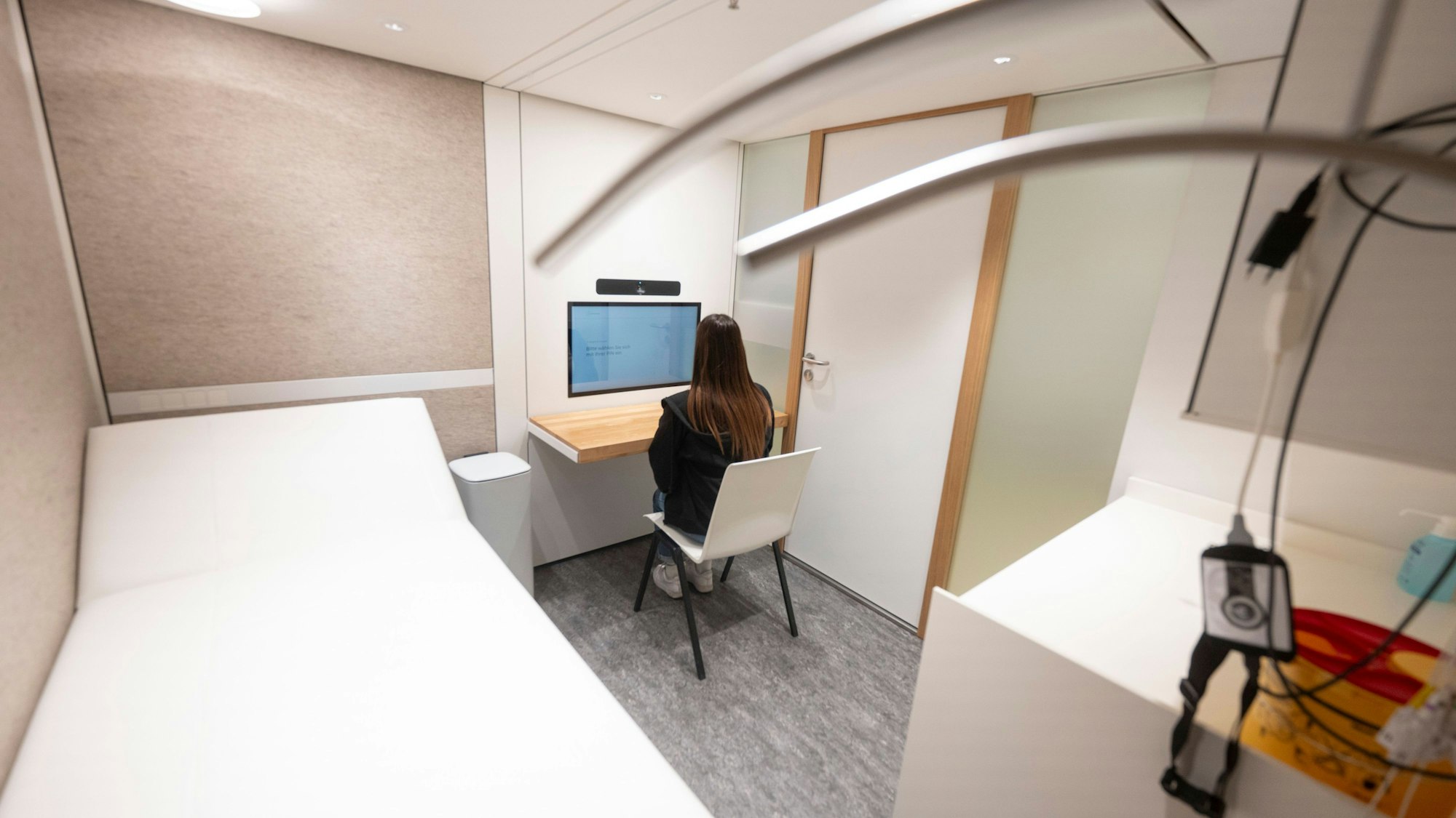 Eine Mitarbeiterin einer Telemedizin-Praxis sitzt in der Praxis in einem Kaufland-Center im Behandlungsraum (gestellte Szene).