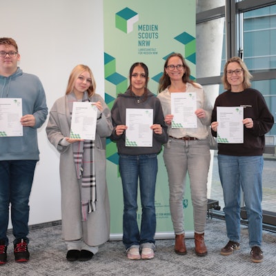 Auf dem Bild sind drei Jugendliche und zwei Frauen zu sehen, die Urkunden in die Kamera halten.