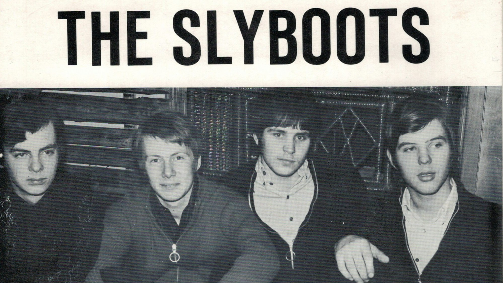 Die Vier Bandmitglieder sitzen am Boden.