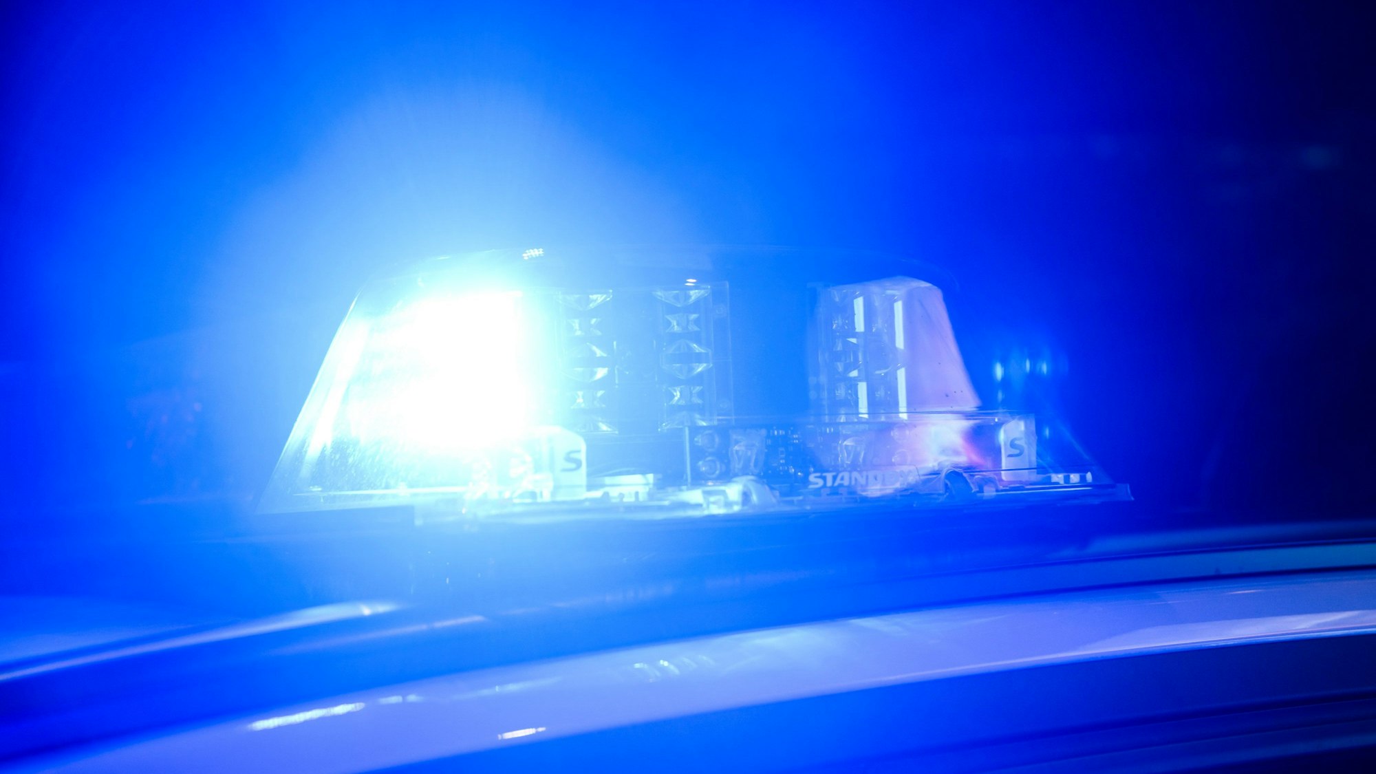 Ein Blaulicht leuchtet auf einem Polizeifahrzeug.