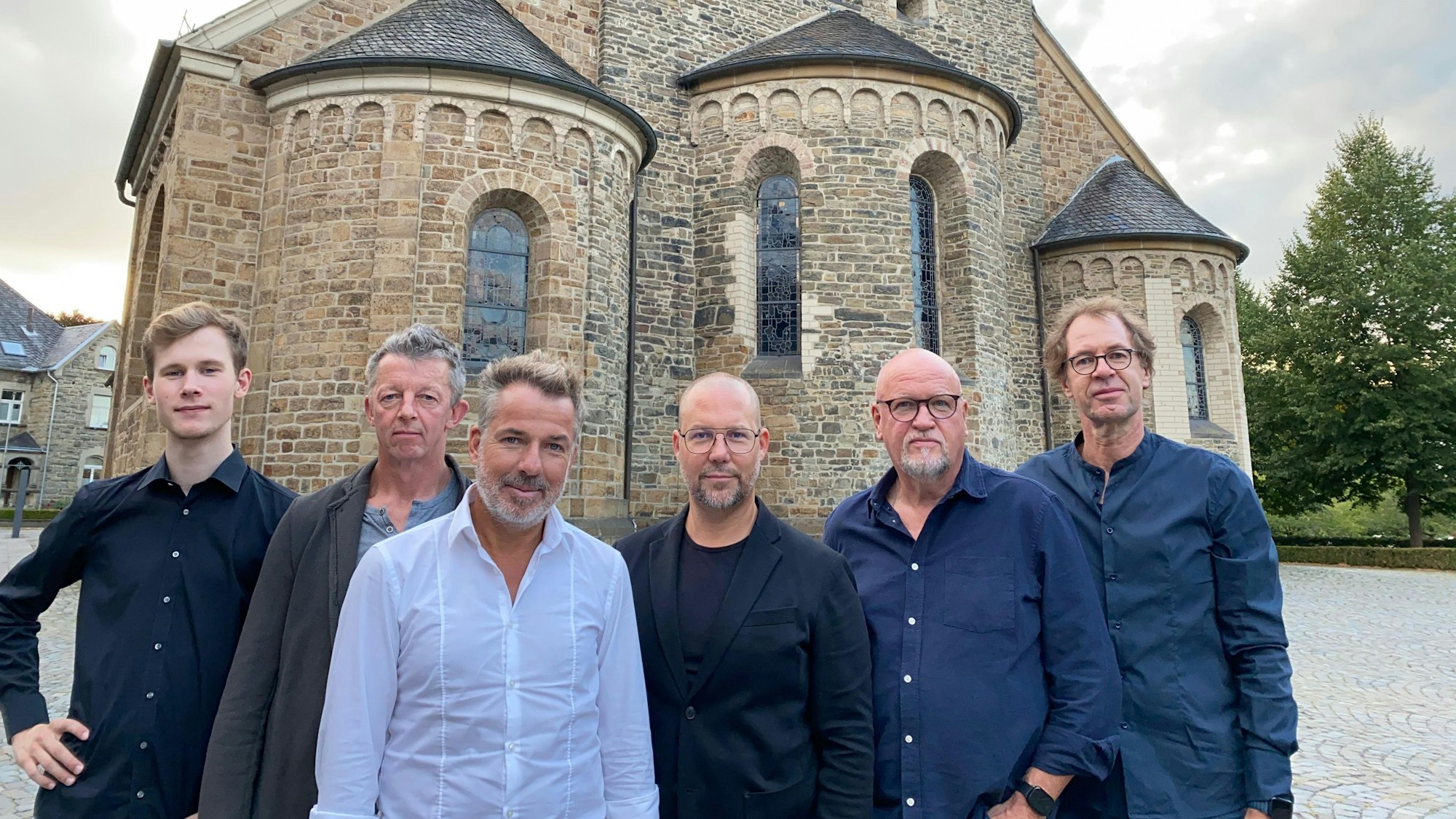 Das Foto zeigt die Musiker von Random's 9 vor der Kirche St. Nikolaus