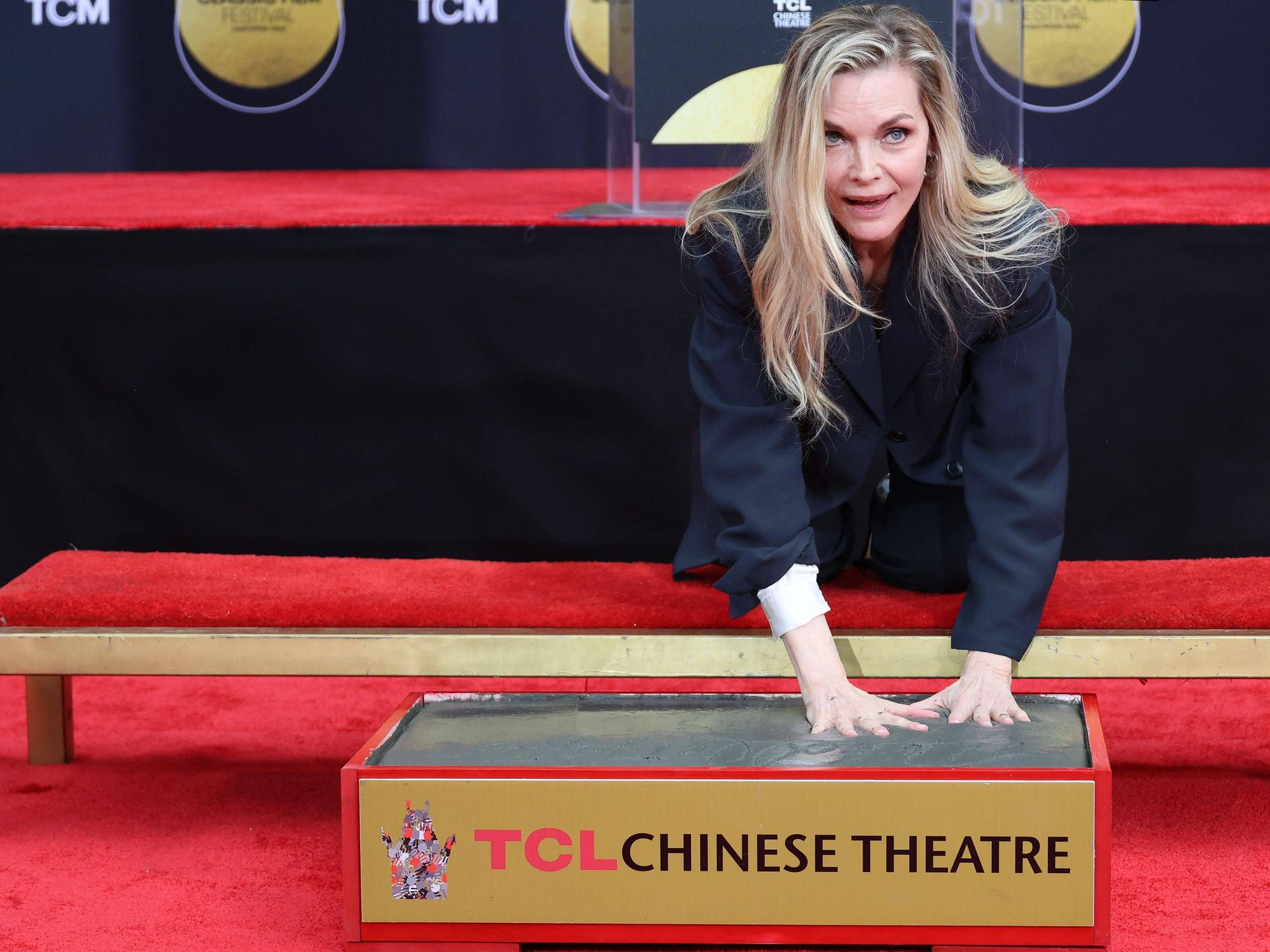 Michelle Pfeiffer drückt ihre Handabdrücke in Zement.