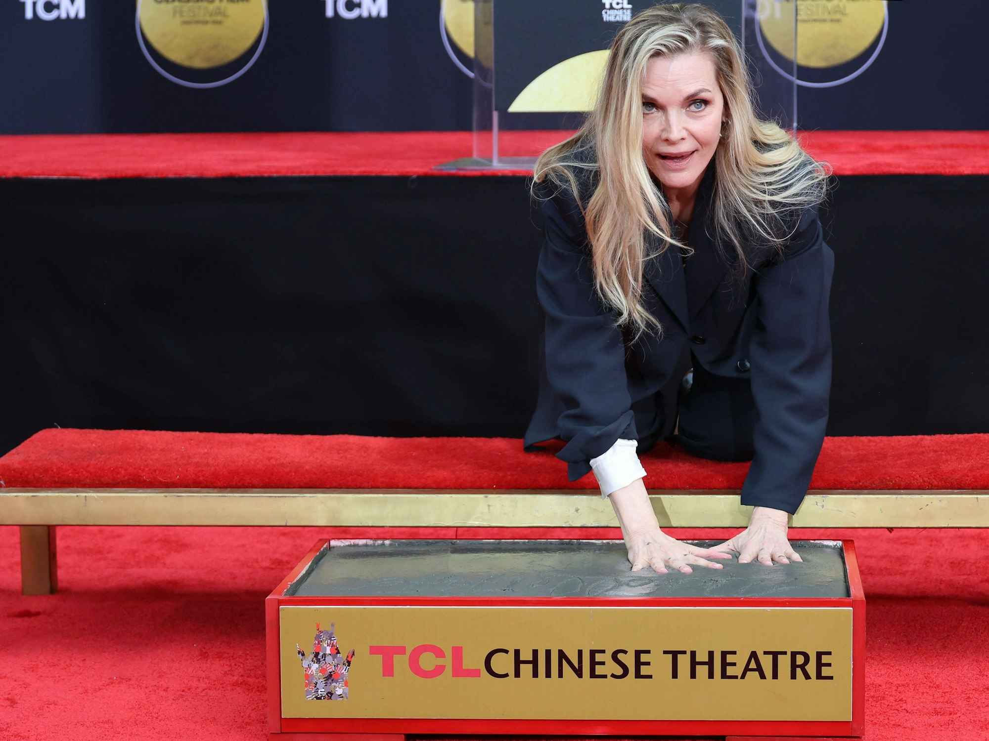 Michelle Pfeiffer drückt ihre Handabdrücke in Zement.
