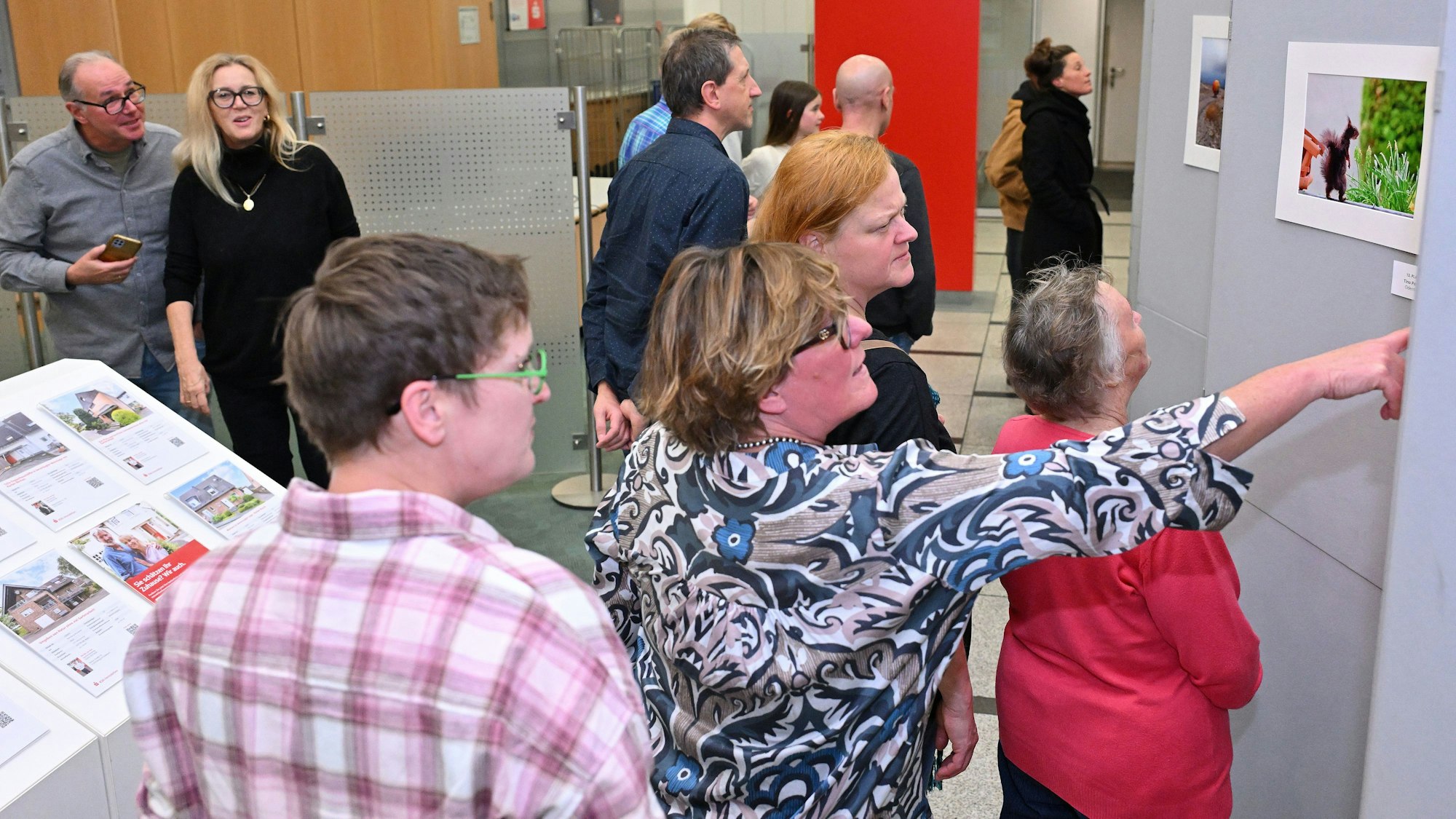 Besuchende betrachten die 15 Siegerfotos.