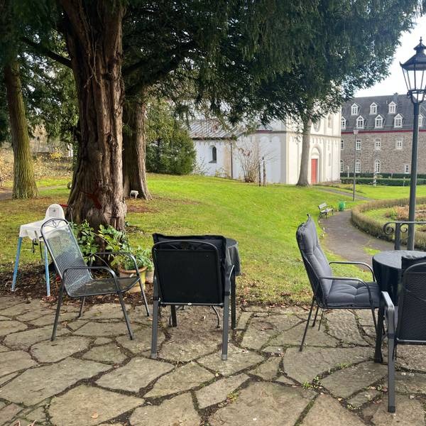 Der Blick von der Terrasse geht in den Schlosspark, auf Springbrunnen, alte Klostergebäude und die Kirche St. Agnes.