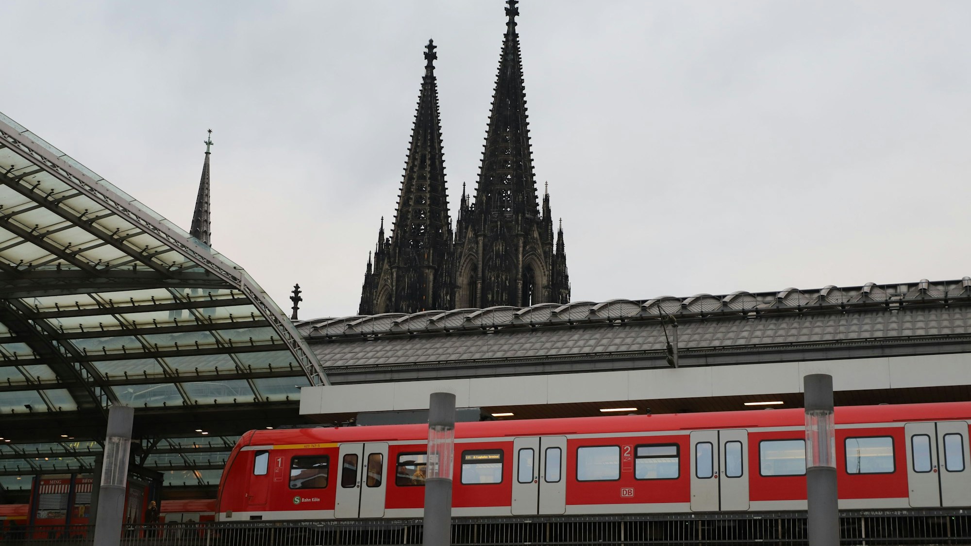 Ein S-Bahn-Zug steht im Kölner Hauptbahnhof. Im Hintergrund ist der Kölner Dom zu sehen.