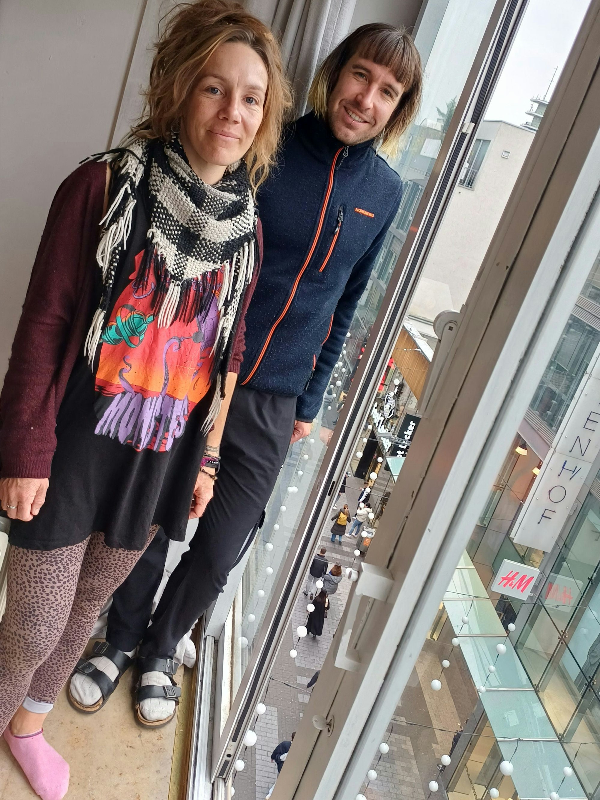 Charlotte Stein und Mitbewohner Hendrik Böwer vor der deckenhohen Fensterfront zur Hohe Straße