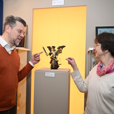 Lukas Schlichtenbrede und Restauratorin Gloria von Hoensbroech zeigen auf eine Darstellung des Erzengels Michael aus dem 17.Jahrhundert.