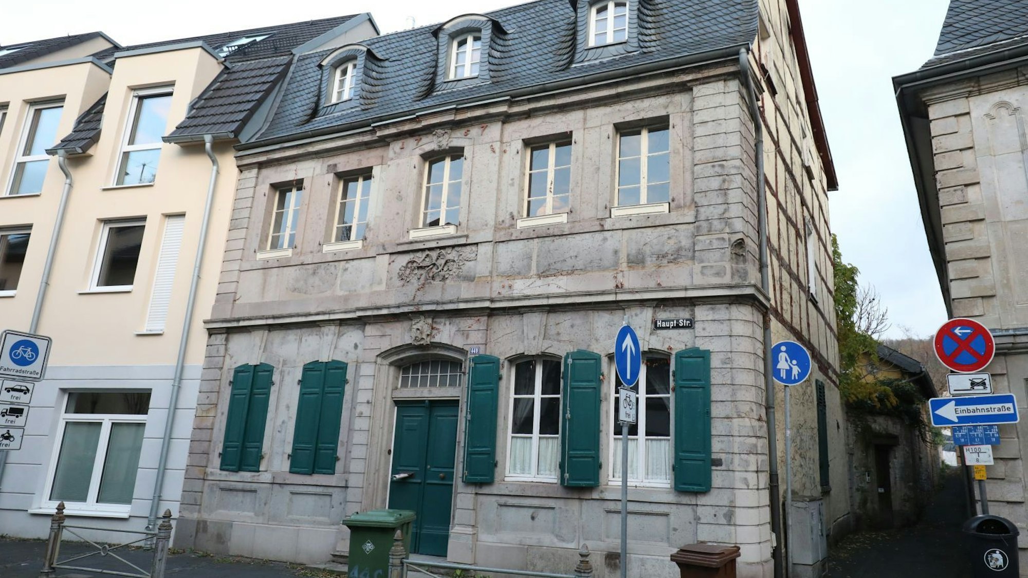 Ein historisches Gebäude mit grünen Fensterläden und einer grünen Eingangstür.