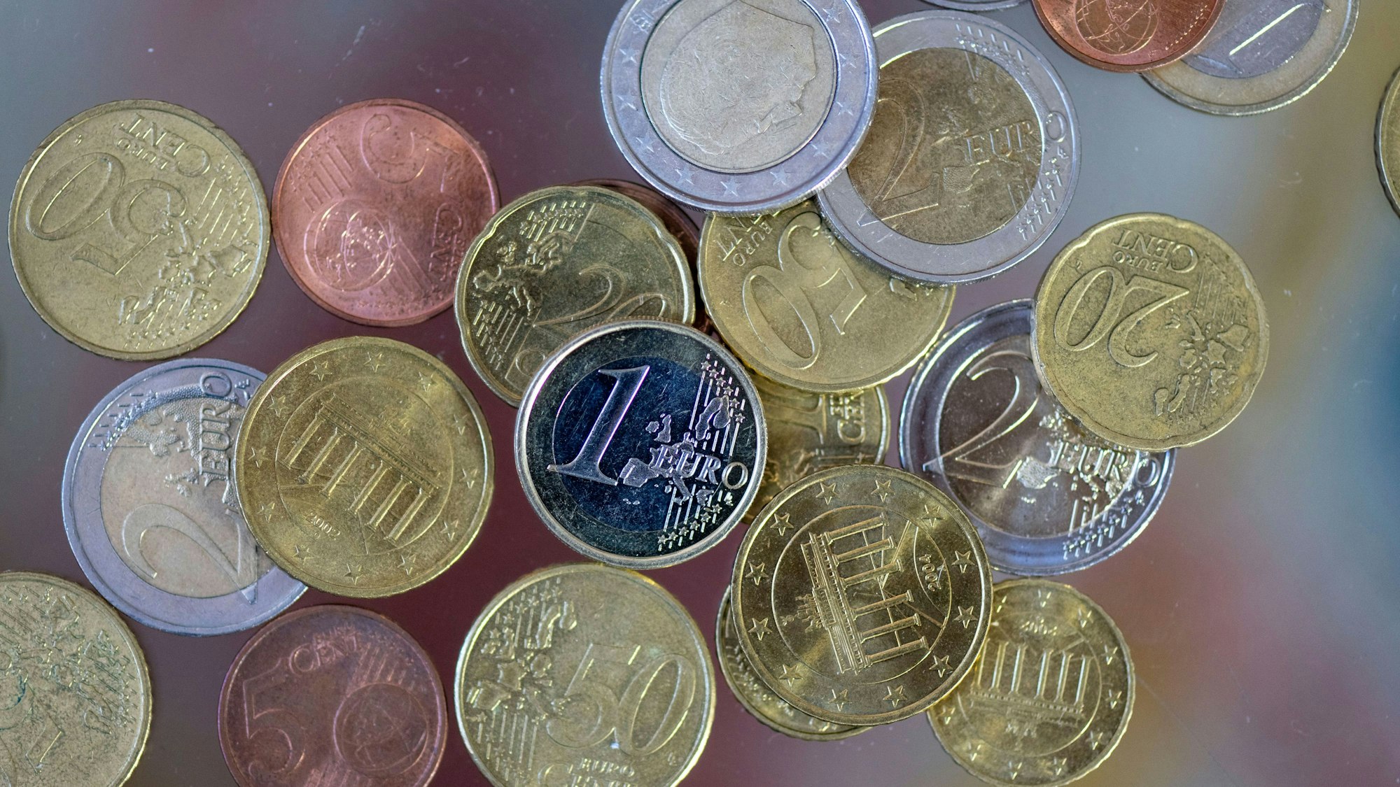 Geldmünzen liegen auf einem Tisch.