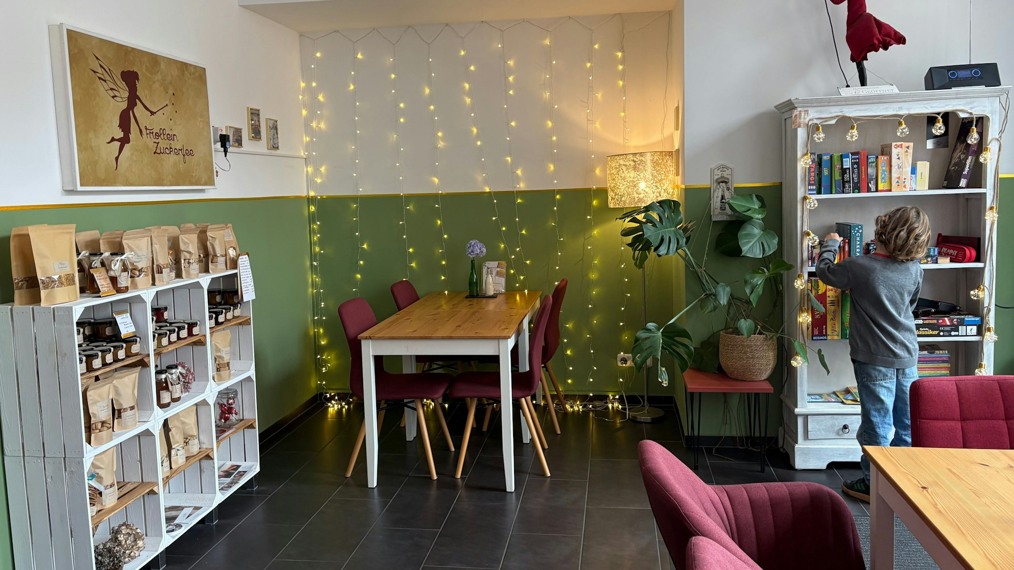 Frollein Zuckerfee mit hübscher Einrichtung und Schrank mit Büchern und Spielen.