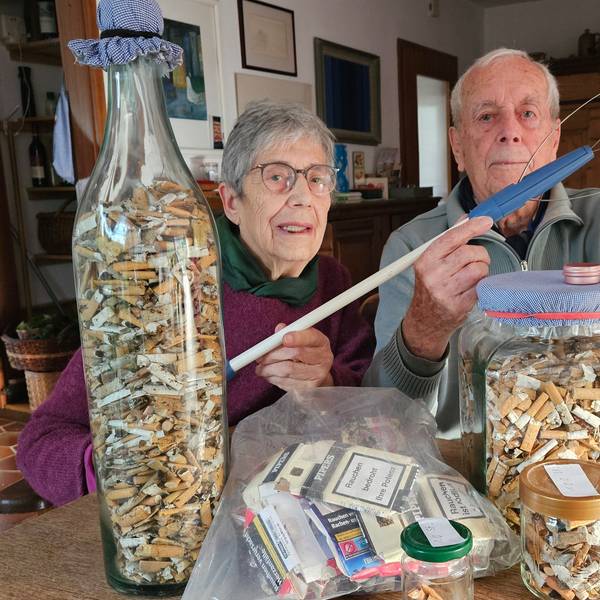 Das Foto zeigt das Ehepaar Margret und Wolfgang Rieve sowie zahlreiche Zigarettenkippen in großen Glasbehältern.