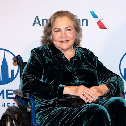 Kathleen Turner sitzt in einem Rollstuhl.