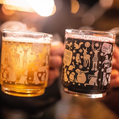 Zwei Frauen stoßen mit einem roten und einem weißen Glühwein an