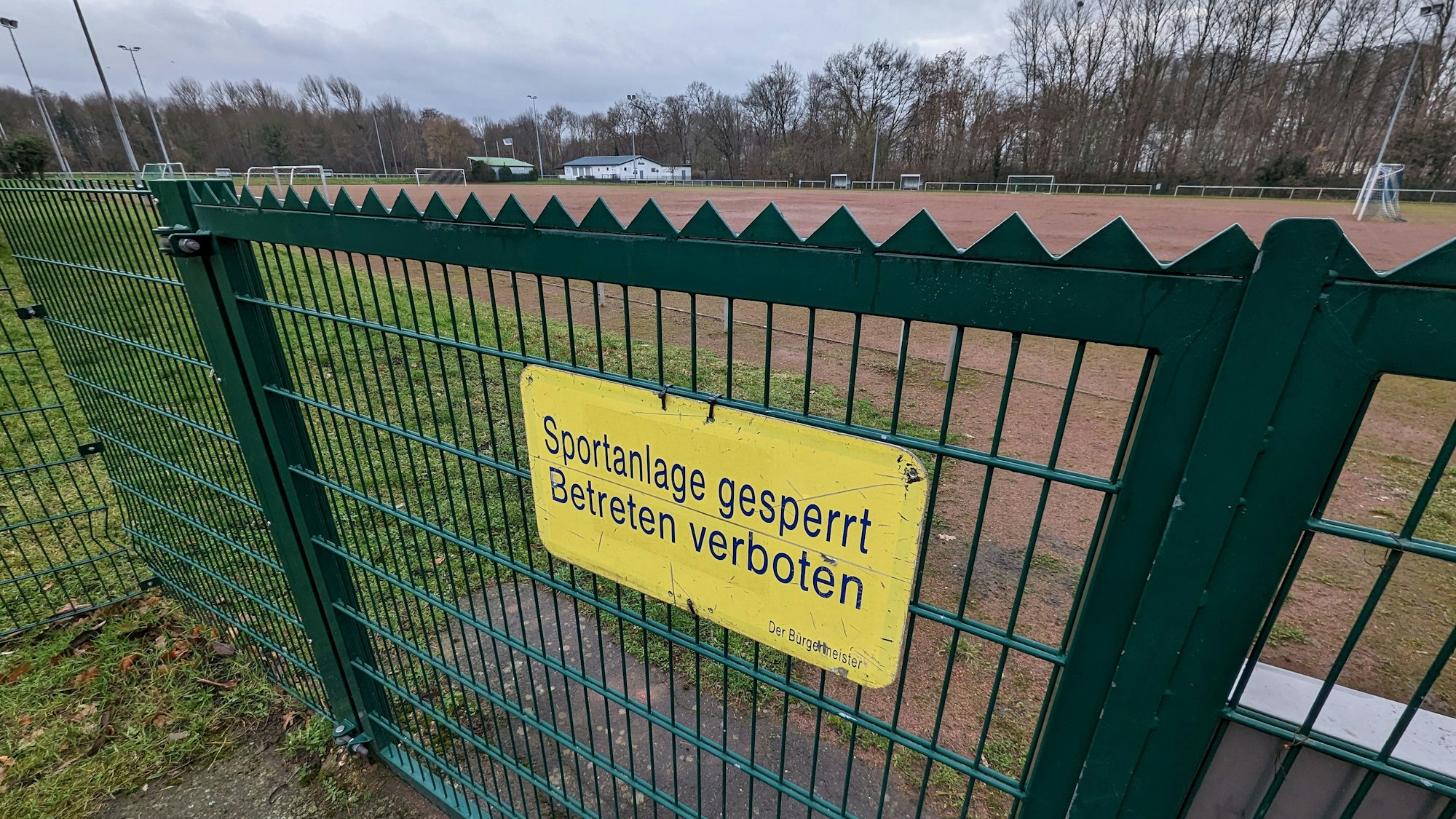 Das Foto zeigt ein Schild mit der Aufschrift „Sportanlage gesperrt“ am Tor vor dem Tennenplatz in Kendenich.