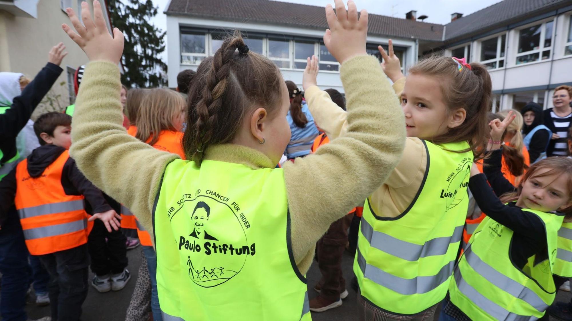 Zu sehen sind Kinder, die Warnwesten tragen.