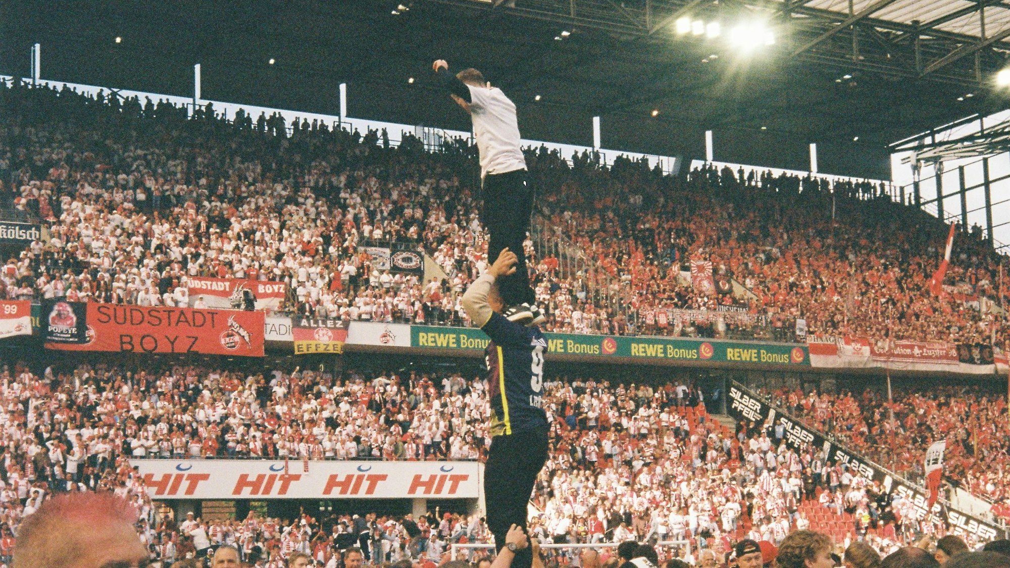 Der 1. FC Köln steigt wieder auf: Szene der Freude spielen sich im Rhein-Energie-Stadion ab. Hier sieht man einen Menschenturm: Einer hält zwei Personen, oben steht ein Kind.