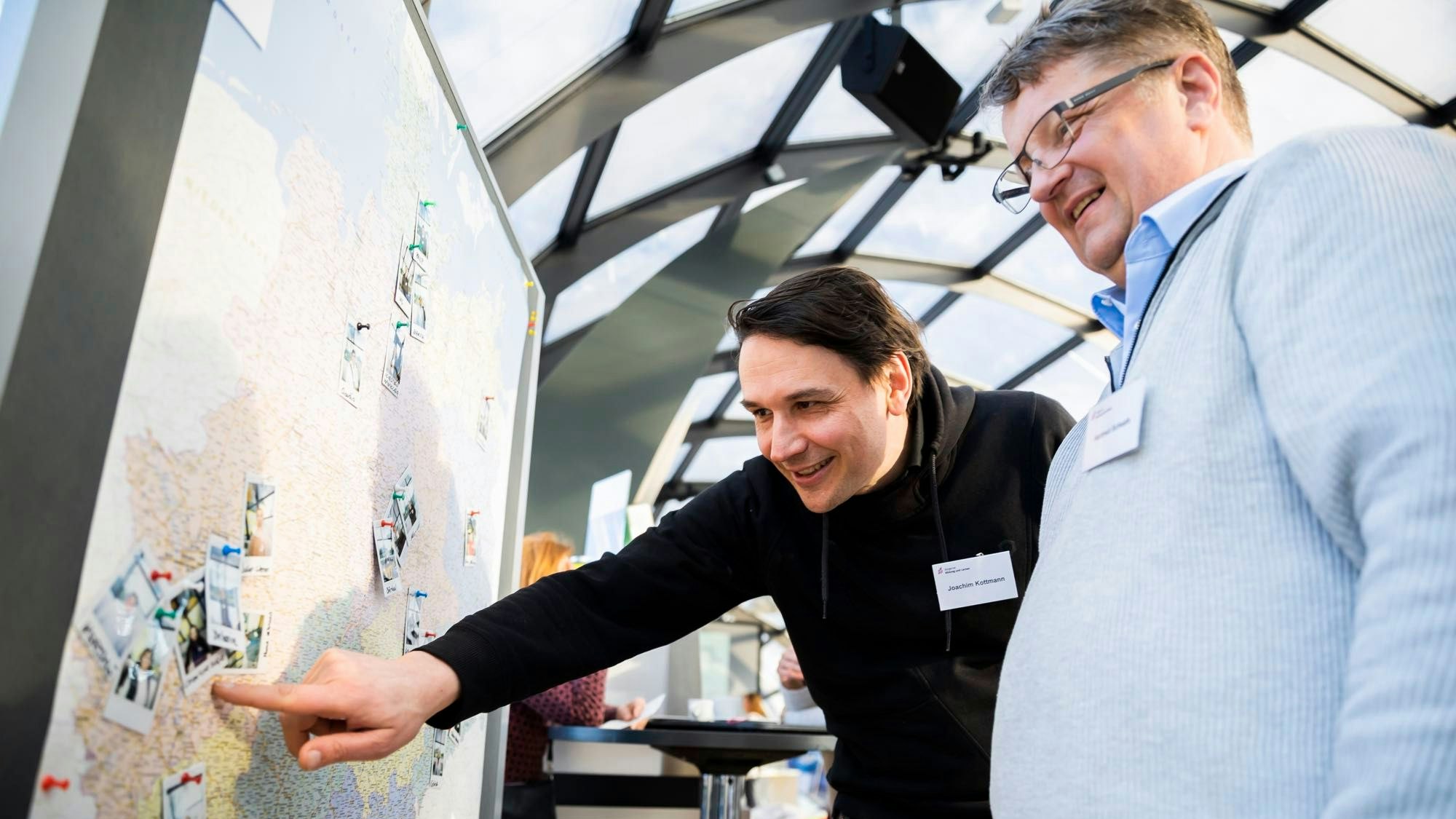 Das Foto zeigt zwei Männer, einer von ihnen zeigt auf einer Deutschlandkarte auf Oberberg