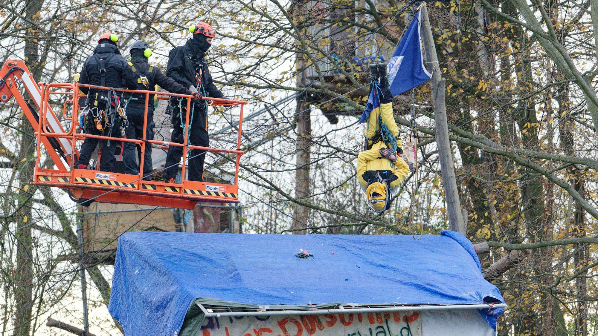 Das Bild zeigt Polizisten, die gegen einen Aktivisten vorgehen, der im sogenannten Sündenwäldchen am Rande des Tagebaus Hambach im Hambacher Forst in einem Baum hängt.