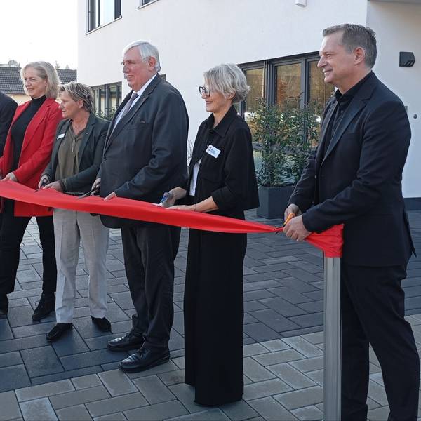 Das Foto zeigt Menschen, die ein rotes Band zerschneiden.