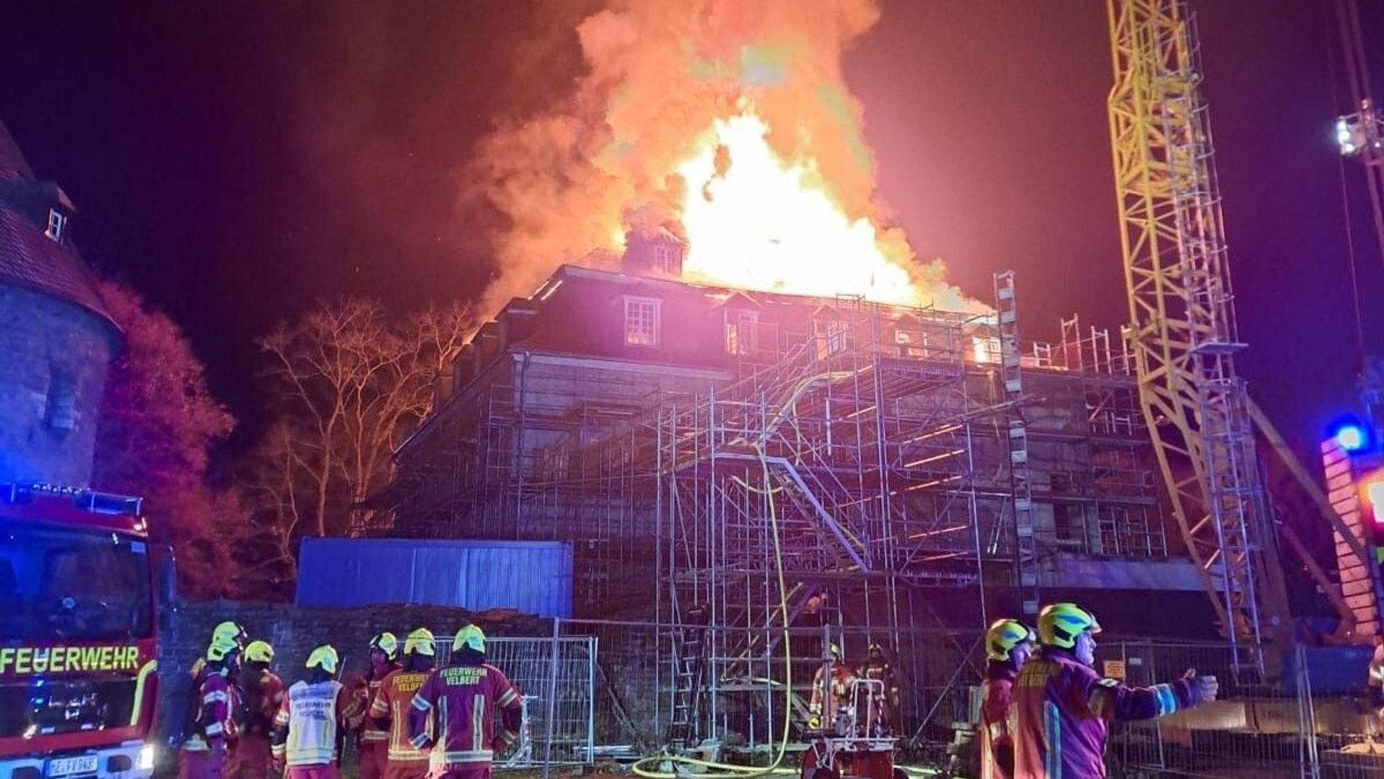 Zwei Feuerwehrmänner versuchen das Feuer im Schloss Hardenberg zu löschen. Das barocke ehemalige Wasserschloss Hardenberg brennt.