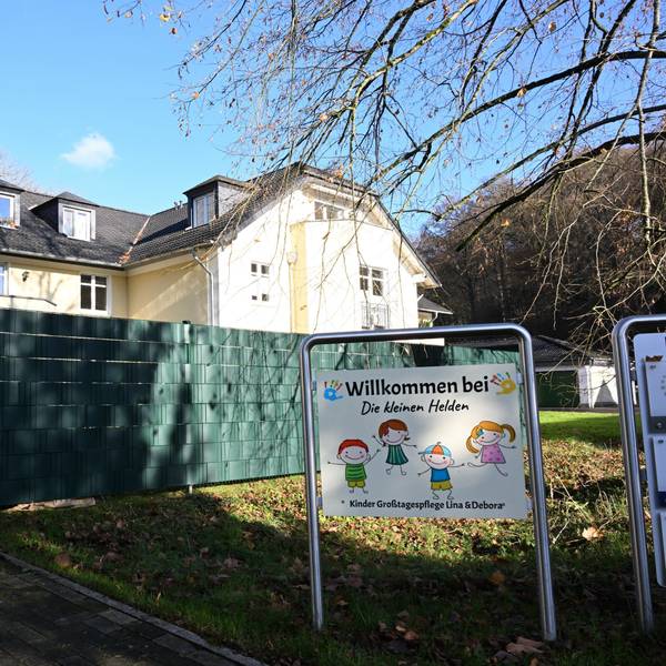 Ein Haus, davor ein Sichtschutz und ein Schild mit der Aufschrift: Willkommen bei „Die kleinen Helden“