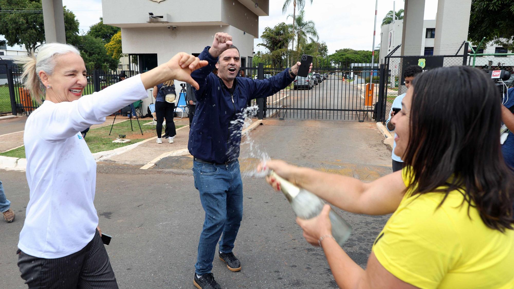 Vor der Bundespolizeizentrale in Brasília stoßen Demonstrierende auf die Festnahme von Jair Bolsonaro an, während sich auf der gegenüberliegenden Straßenseite seine Anhänger versammeln. Der frühere Präsident war am Morgen aus dem Hausarrest in Polizeigewahrsam überstellt worden.