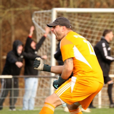 Dominik Schöpfer ballt die Faust und schreit. Auch im Hintergrund jubeln Anhänger und Spieler des SV Frauenberg