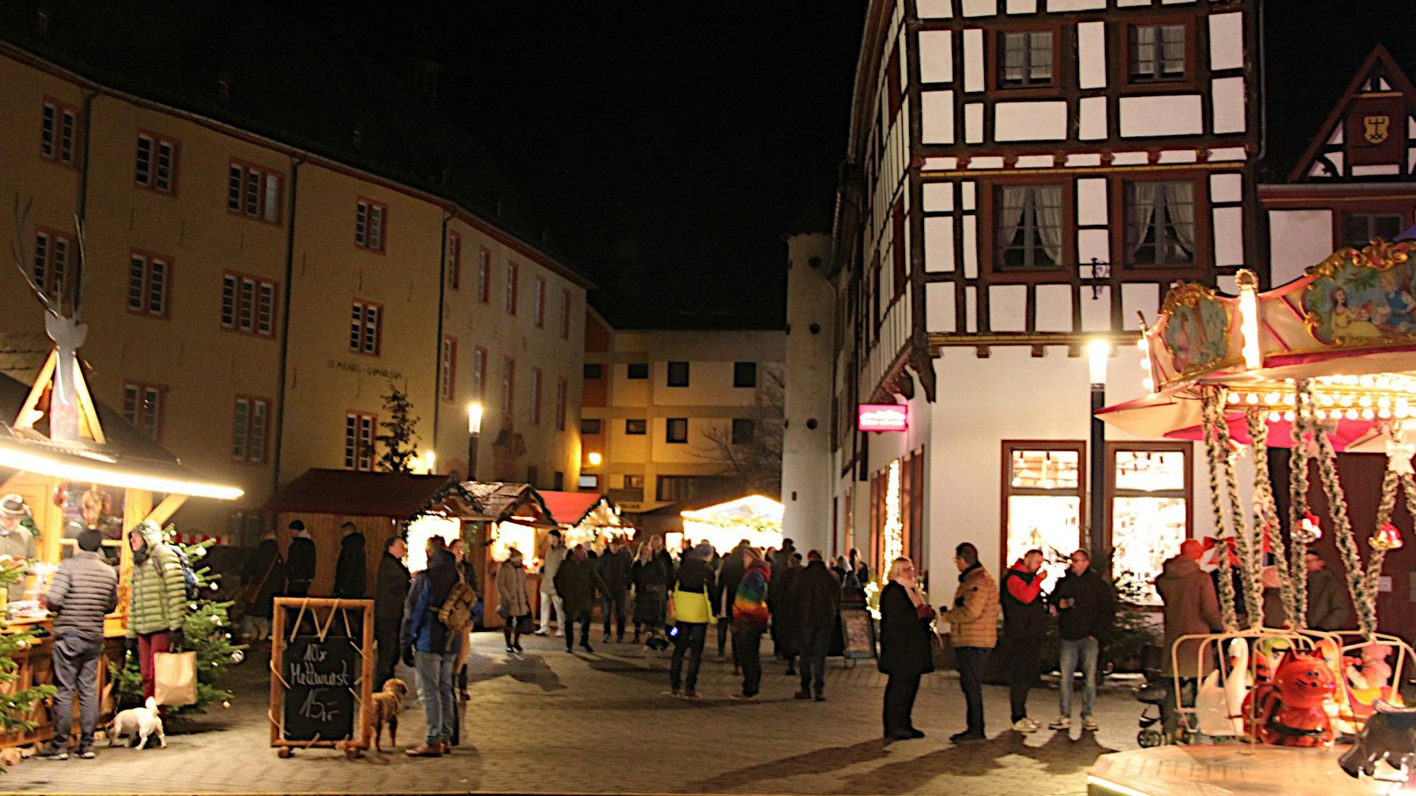 Blick auf den stimmungsvoll erleuchteten Weihnachtsmarkt mit den Häusern der historischen Altstadt.