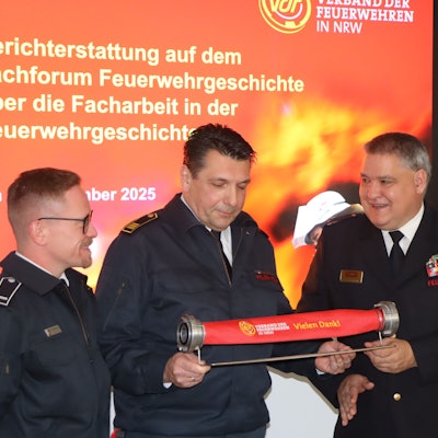 Das Foto zeigt Feuerwehrmänner, die einen kurzen Schlauch in der Hand halten.