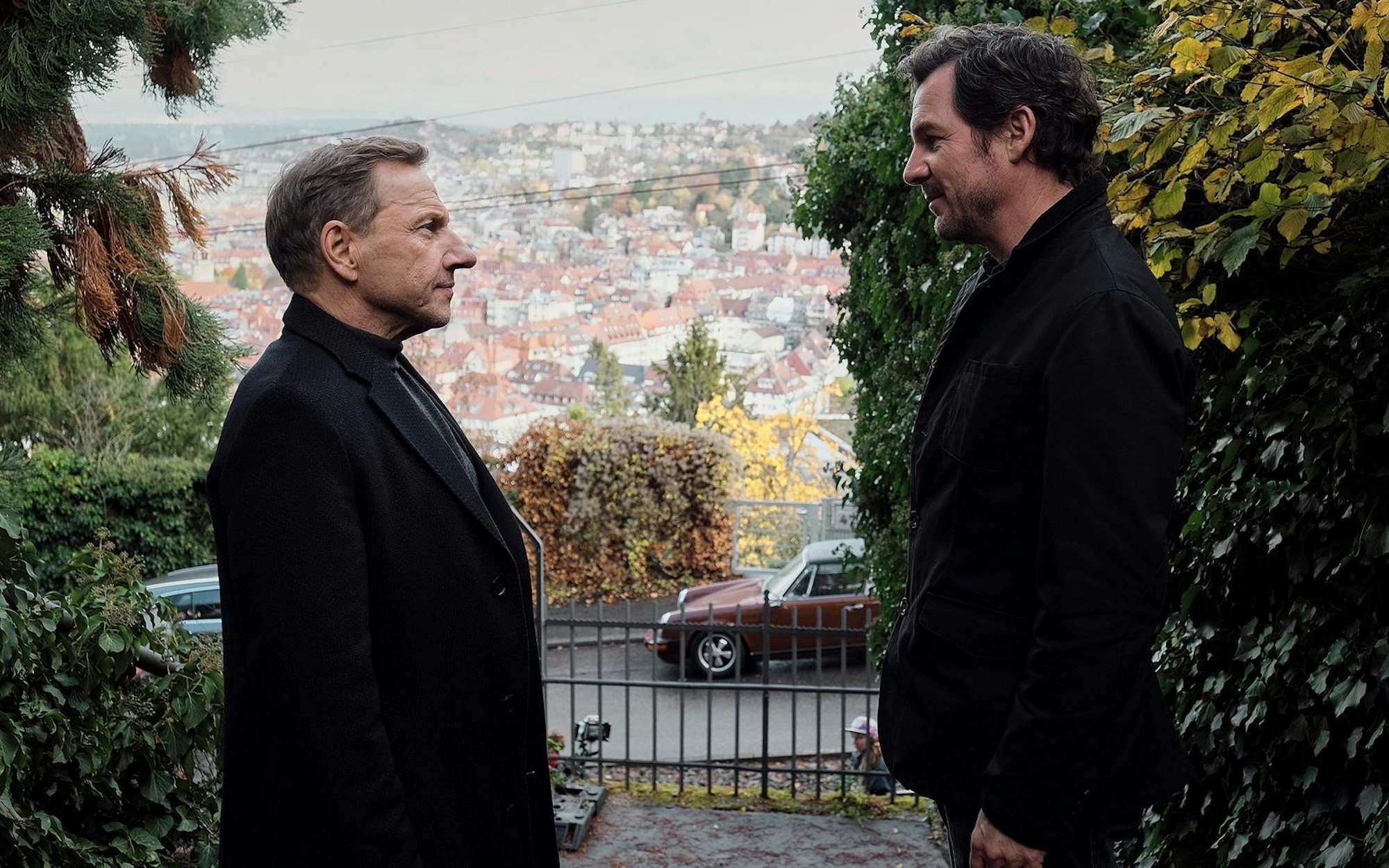 Schöne Stadt, traurige Leben: Die Ermittler Sebastian Bootz (Felix Klare, rechts) und Thorsten Lannert (Richy Müller) diskutieren im „Tatort: Überlebe wenigstens bis morgen“ vor Stuttgarter Kulissen über die Einsamkeit der Jungen. (Bild: SWR/Benoît Linder)