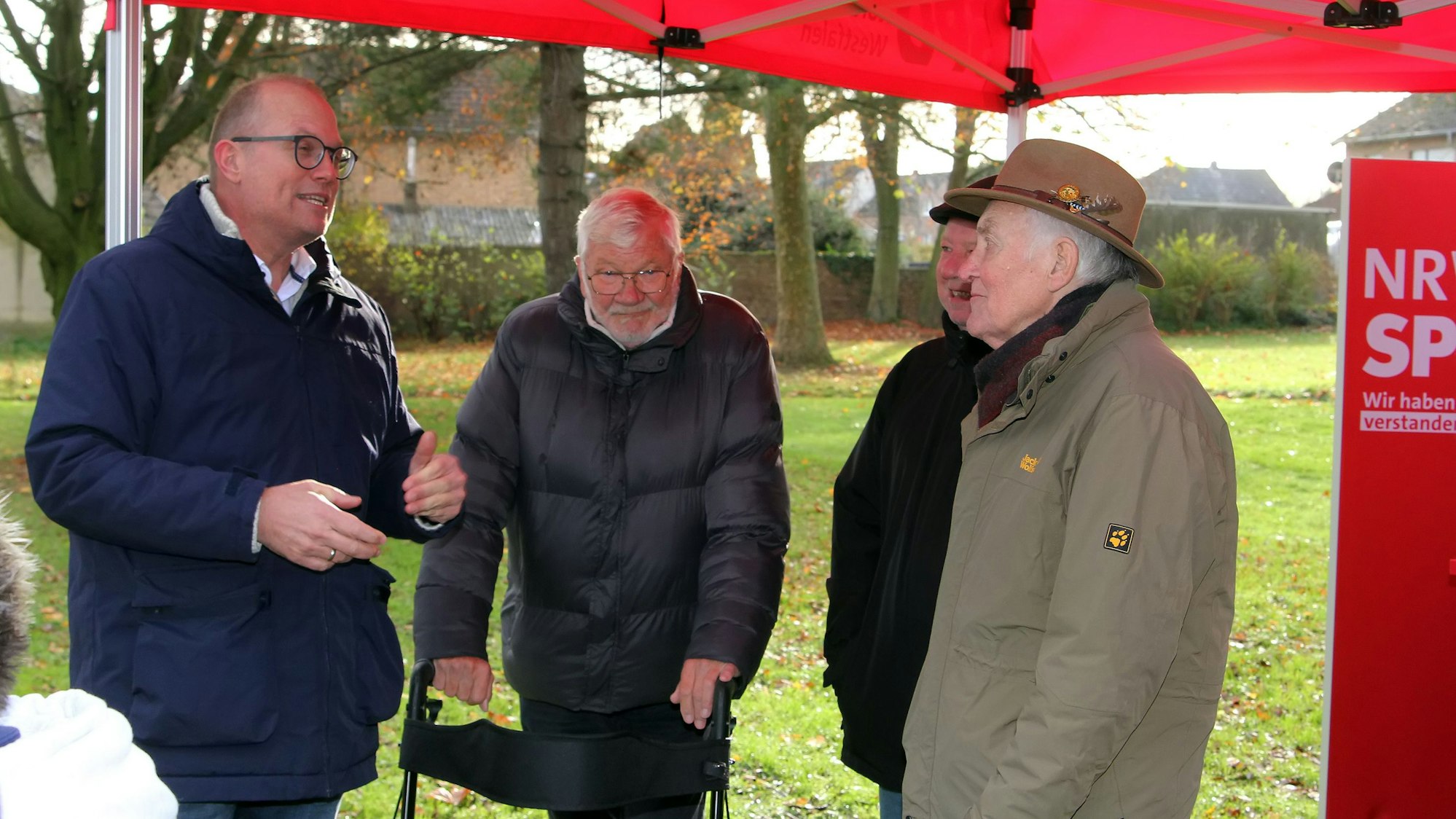 Das Foto zeigt vier Männer, die sich unterhalten.