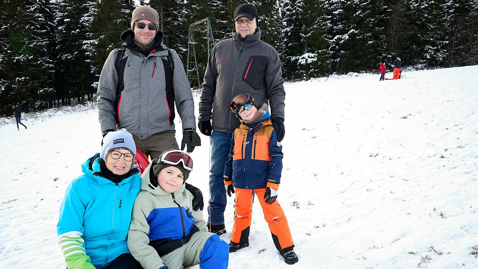 Die Familie mit zwei Kindern auf dem Rodelhang.