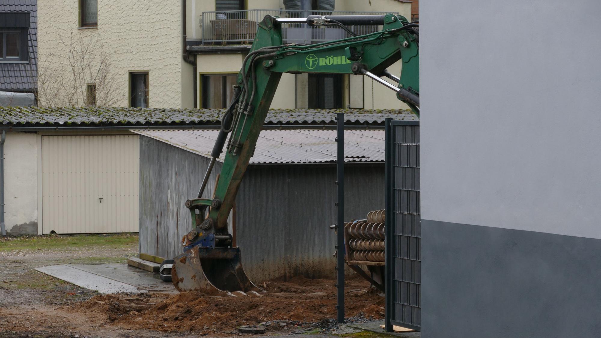 Ein Bagger eines spezialisierten Tiefbauunternehmens steht in dem Hinterhof, wo der Blindgänger entdeckt wurde.