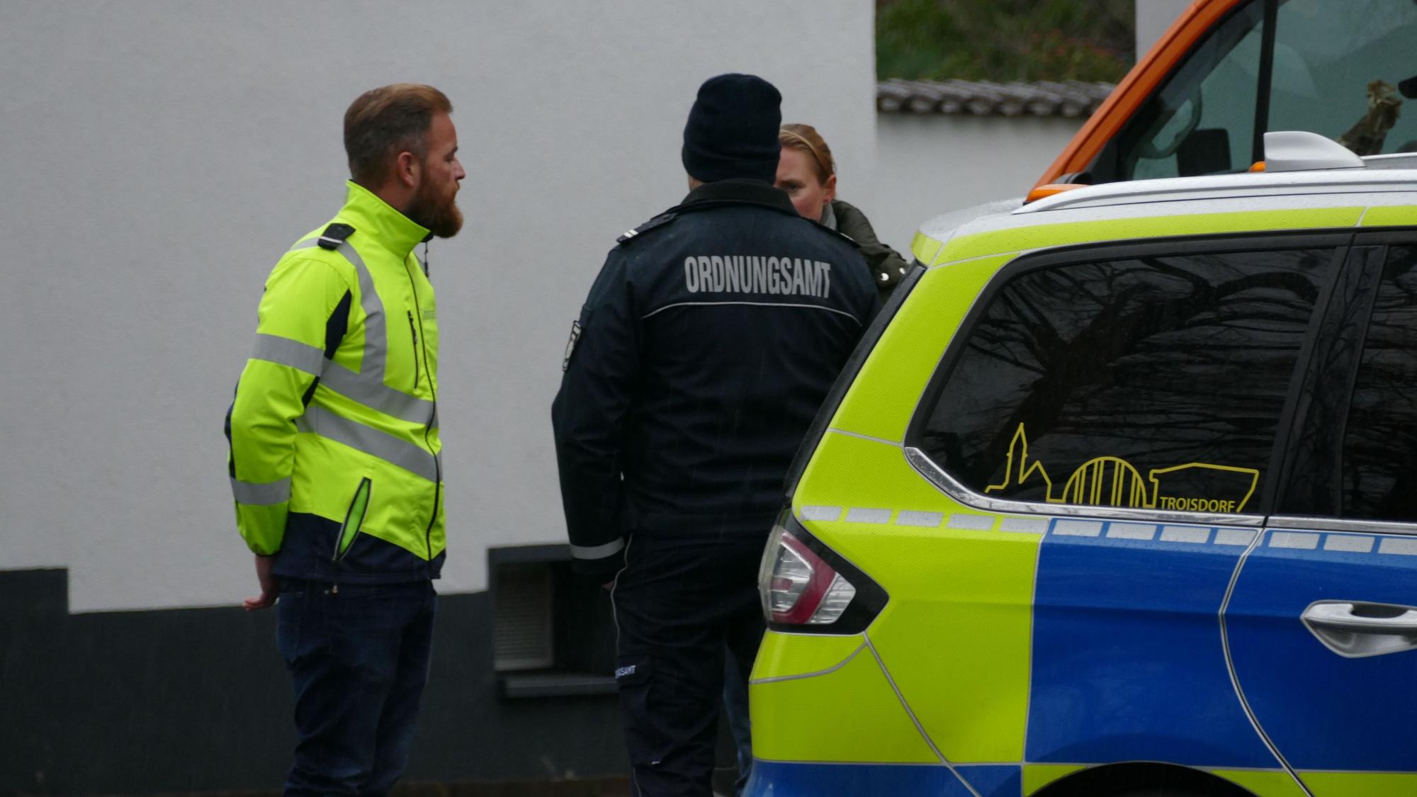 Mitarbeiter des Kampfmittelräumdienstes und des Ordnungsamts stehen vor dem betroffenen Haus.