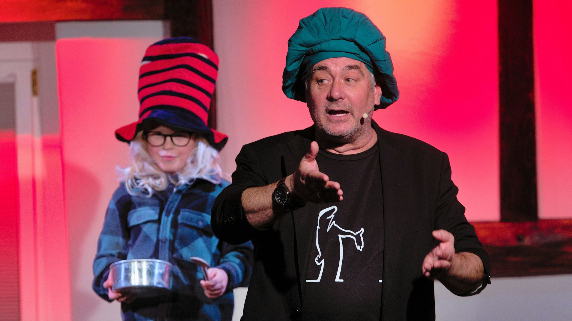 Ein Mann und ein kostümiertes Kind auf der Bühne.