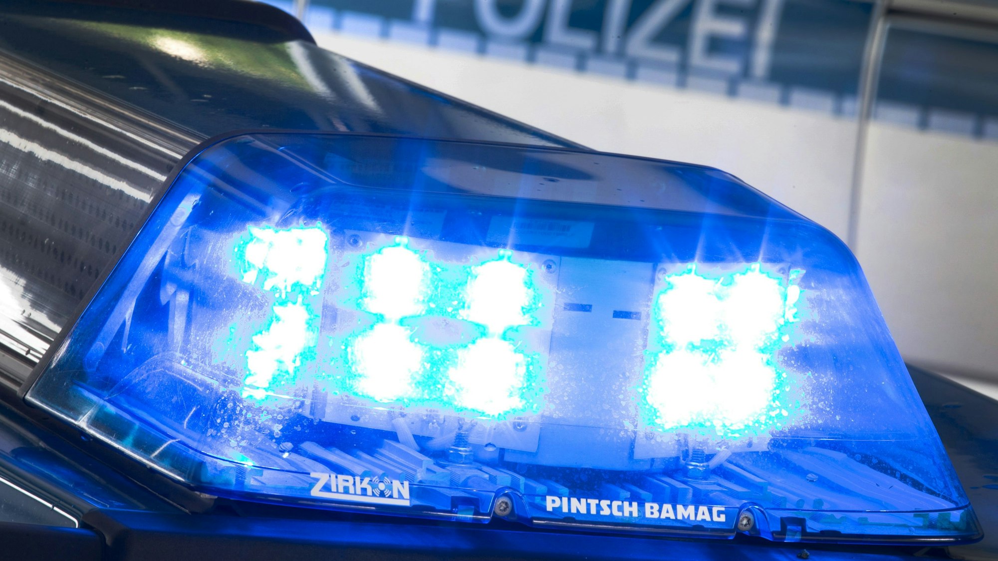 Ein Blaulicht leuchtet auf dem Dach eines Polizeiwagens.