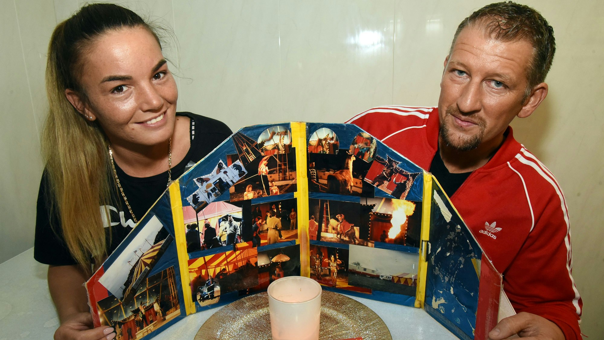 Angel und Angelo Bügler am Tisch mit ein Plakat vom Zirkus.