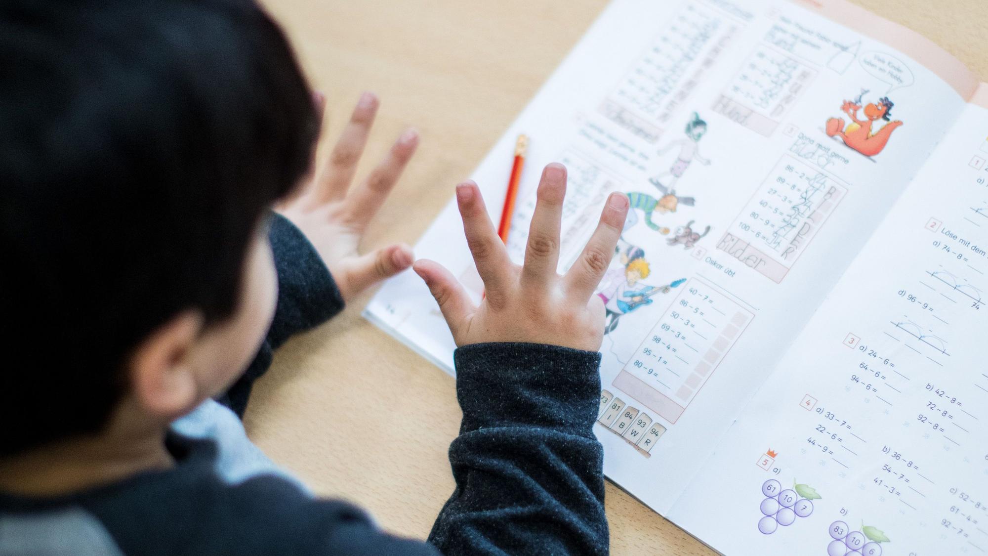 Ein Junge rechnet im Klassenraum einer Grundschule in Essen (Nordrhein-Westfalen) während einer Mathe-Übung mit den Fingern.