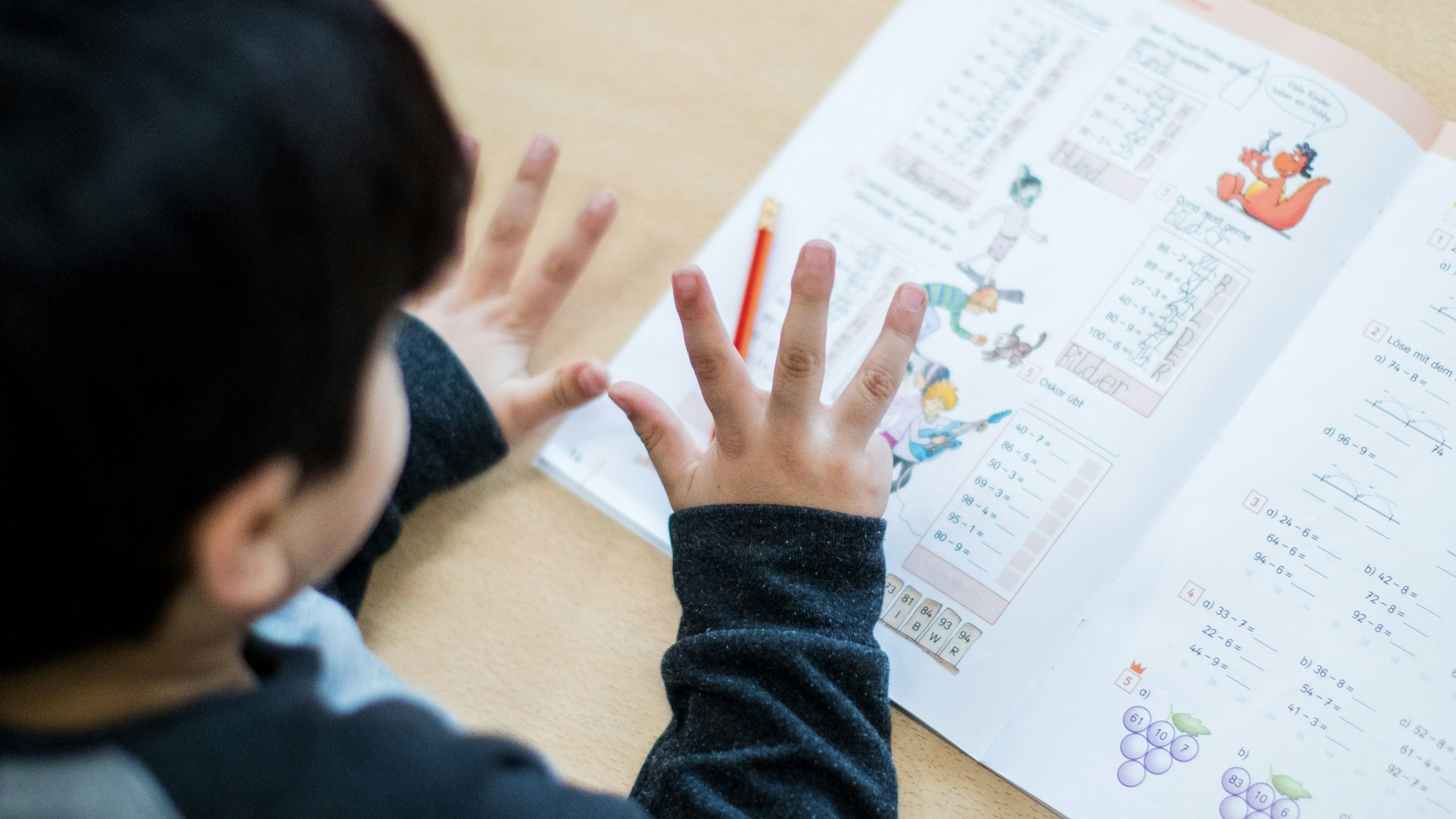 Ein Junge rechnet im Klassenraum einer Grundschule in Essen (Nordrhein-Westfalen) während einer Mathe-Übung mit den Fingern.
