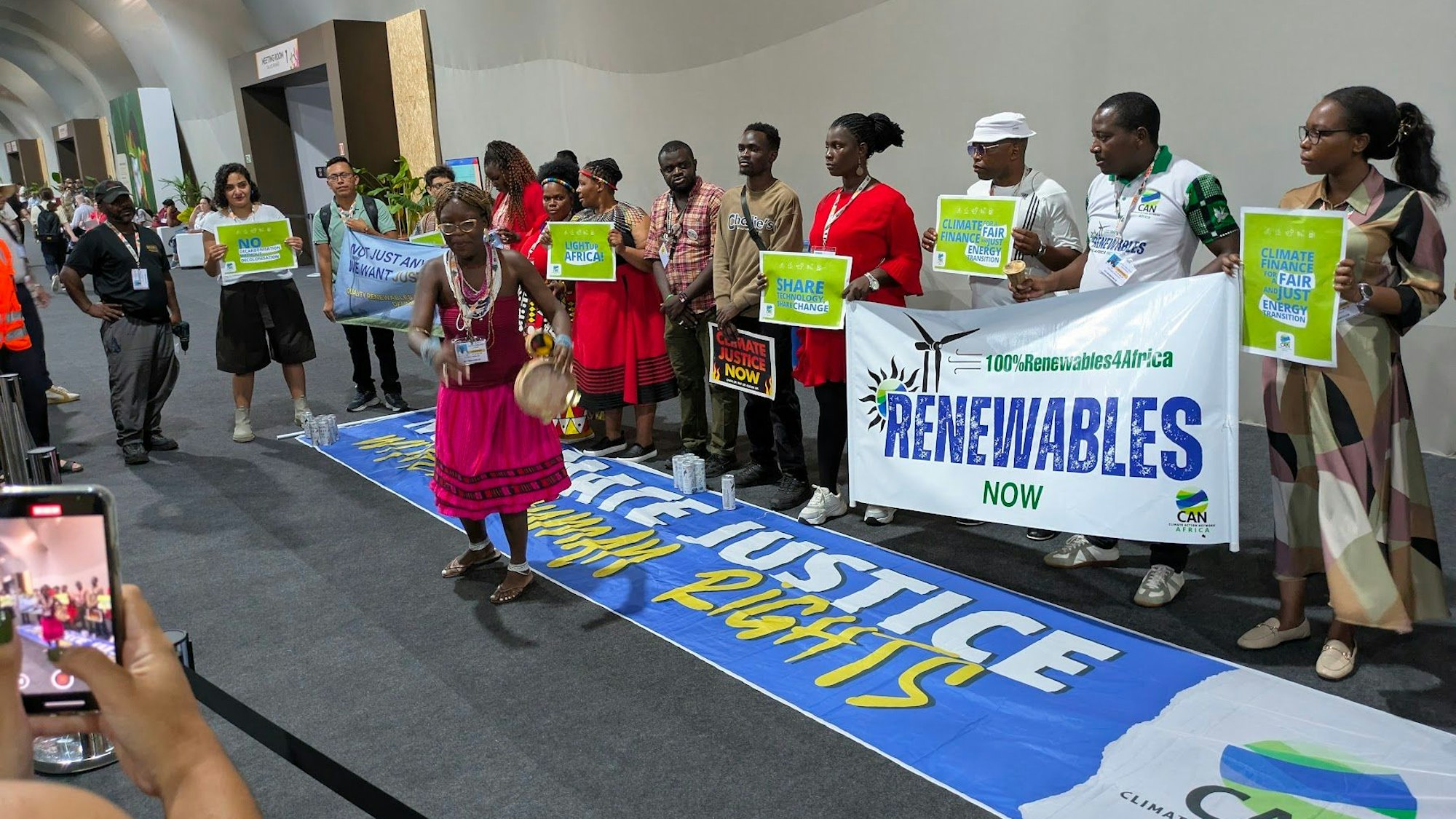 Afrikanische Aktivisten demonstrieren mit Spruchbändern für Klimagerechtigkeit.