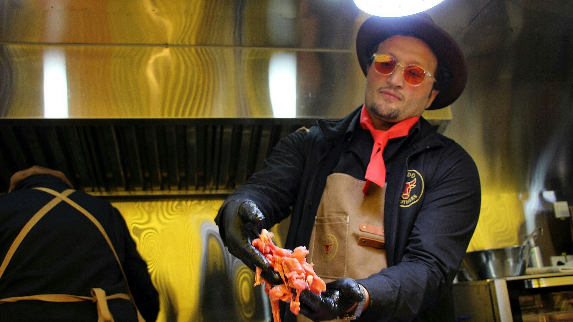 Auf dem Bild ist ein Mann mit Schürze in dem Foodtruck zu sehen.