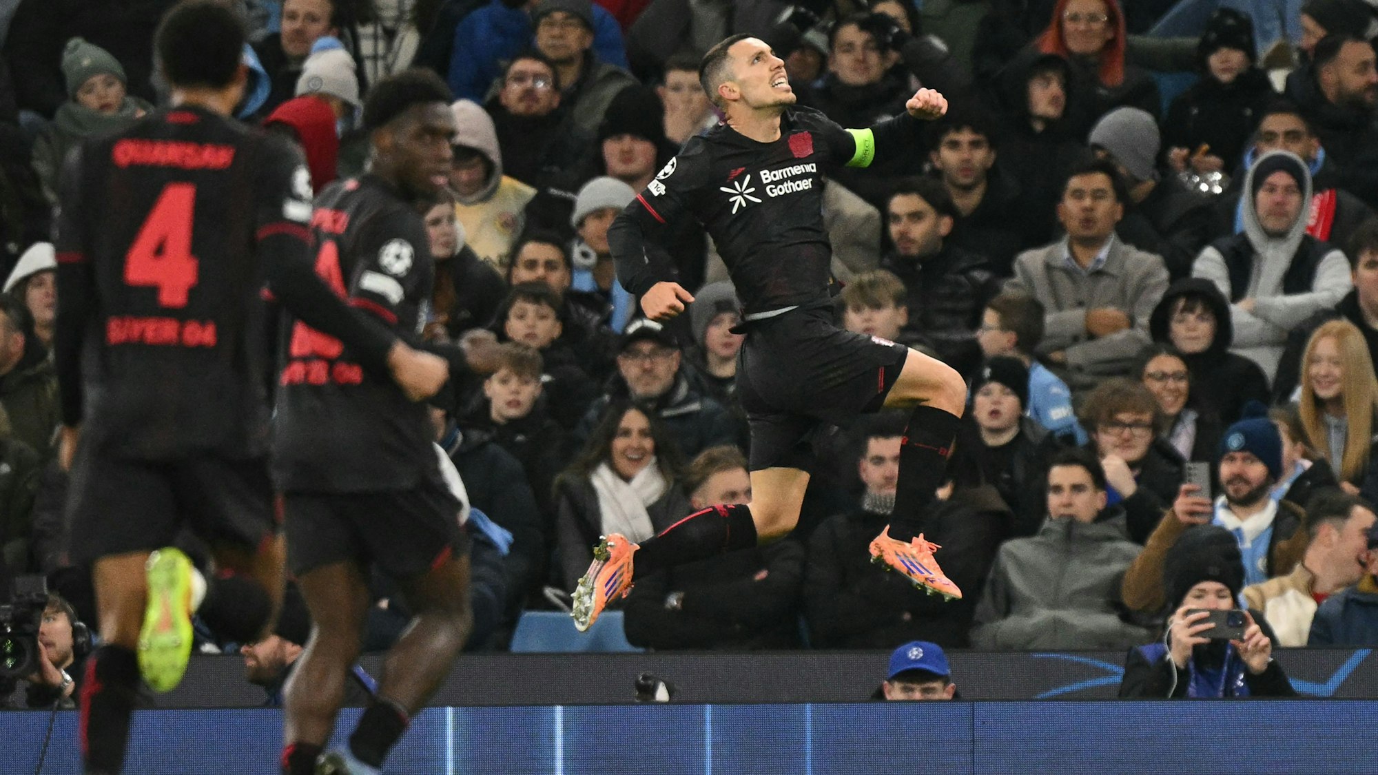 TOPSHOT - Bayer Leverkusen's Spanish defender #20 Alejandro Grimaldo celebrates after scoring the opening goal during the UEFA Champions League league-stage football match between Manchester City and Bayer Leverkusen at the Etihad Stadium in Manchester, north west England, on November 25, 2025. (Photo by Oli SCARFF / AFP)