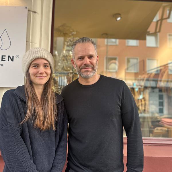 Eine Frau mit langem Haar und Wollmütze steht neben einem Mann mit grauem Haar und Bart.